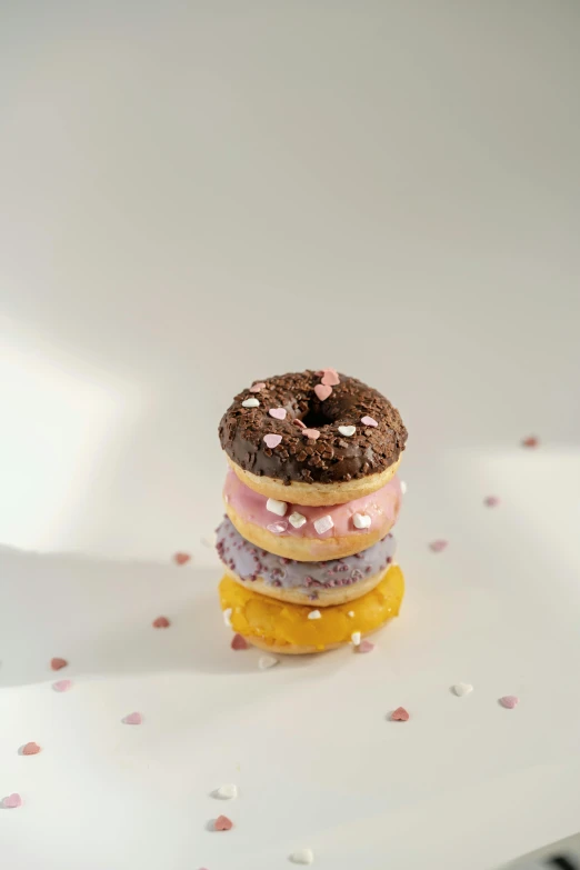 a stack of donuts sitting on top of a white plate, by Nina Hamnett, made out of sweets, hearts, ground - level medium shot, low quality photo