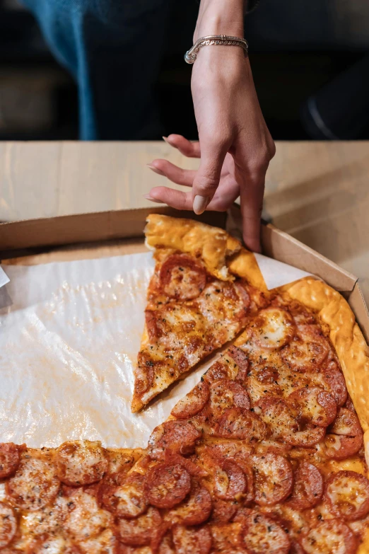 a person grabbing a slice of pizza out of a box, up-close, giant, 2019 trending photo, high angle close up shot