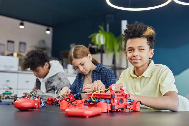 a couple of kids that are sitting at a table, pexels contest winner, ashcan school, red and black robotic parts, avatar image, teenage boy, group photo