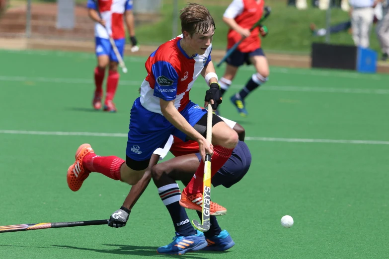 a group of young men playing a game of field hockey, red and blue garments, lachlan bailey, profile pic, high quality image