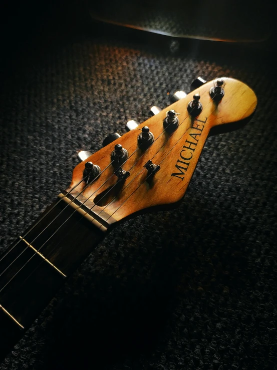 a close up of a guitar neck on a carpet, by Leo Michelson, pexels contest winner, photorealism, front lit, michael vicente, head shot, screw