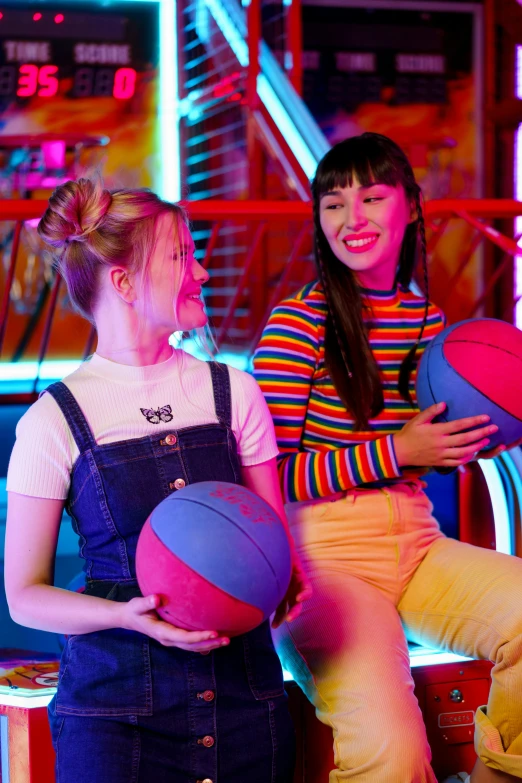 a couple of women sitting next to each other, trending on dribble, neon lights in the background, softplay, playing basketball, colourful clothing