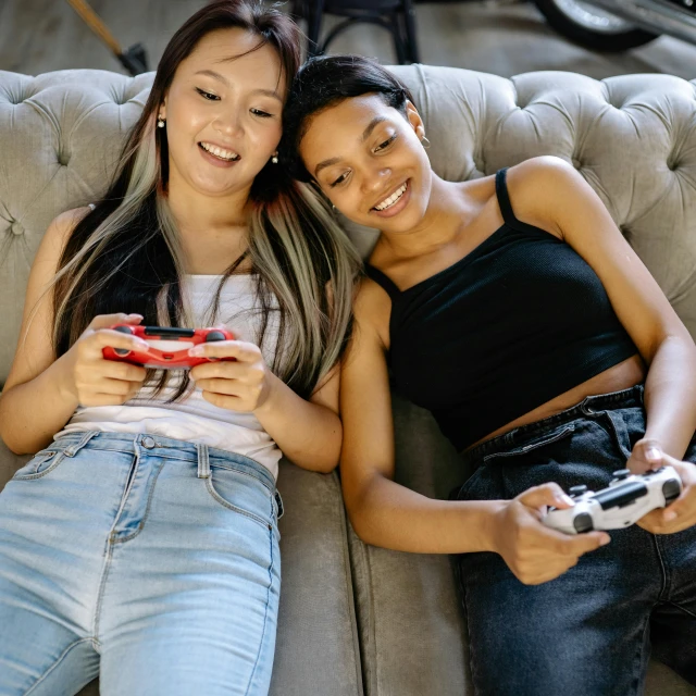 a couple of women laying on top of a couch, trending on pexels, video game icon, high school, handheld, 15081959 21121991 01012000 4k