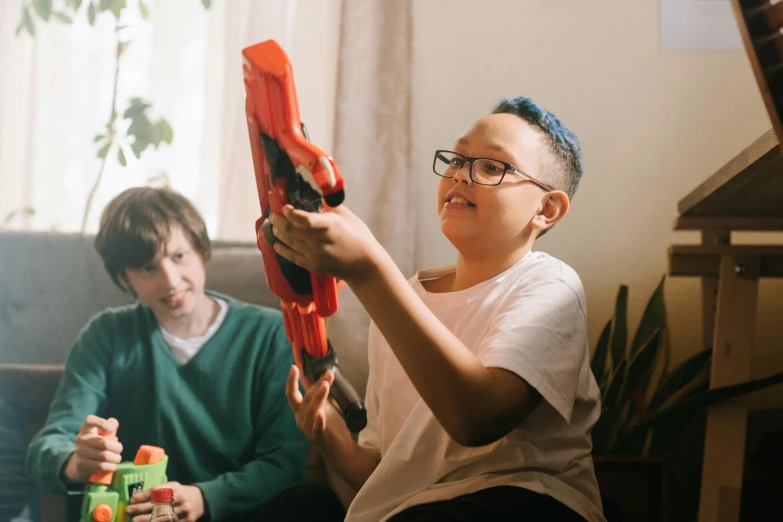 a couple of kids sitting on top of a couch, pexels contest winner, next to it is a toy ray gun, over his shoulder, transformers toys, avatar image