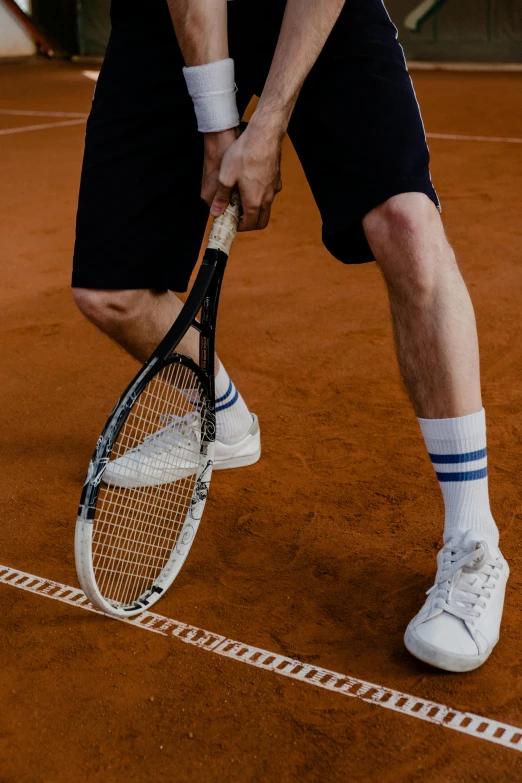 a man holding a tennis racquet on a tennis court, inspired by Hans Mertens, legs and arms, zoomed in, profile image