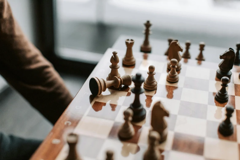 a person playing a game of chess on a table, by Emma Andijewska, unsplash contest winner, 🦩🪐🐞👩🏻🦳, zoomed in, battle position, schools