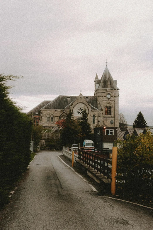 a street with a church in the background, an album cover, inspired by Thomas Struth, unsplash, vancouver school, in scotland, gloomy library, bridge, private school