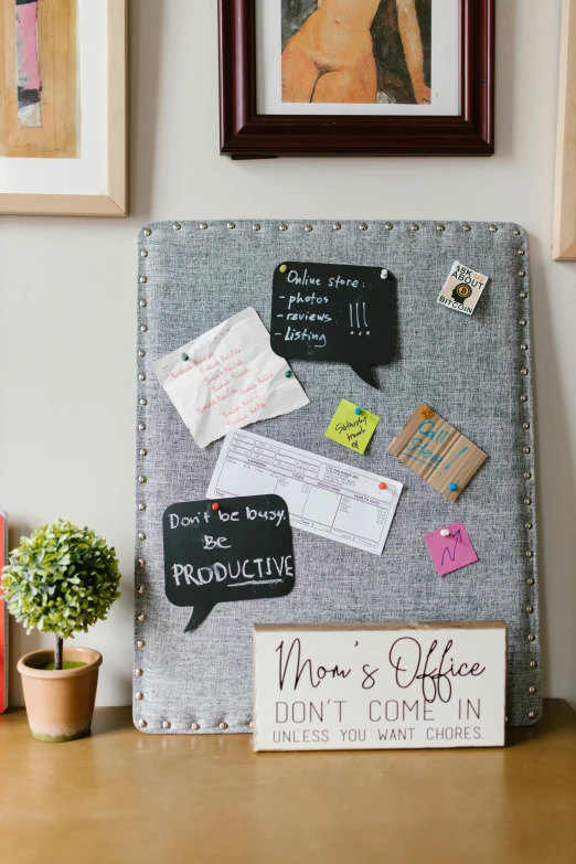 a bulletin board sitting on top of a wooden table, trending on pinterest, plush leather pads, speech bubbles, angled shot, gray canvas