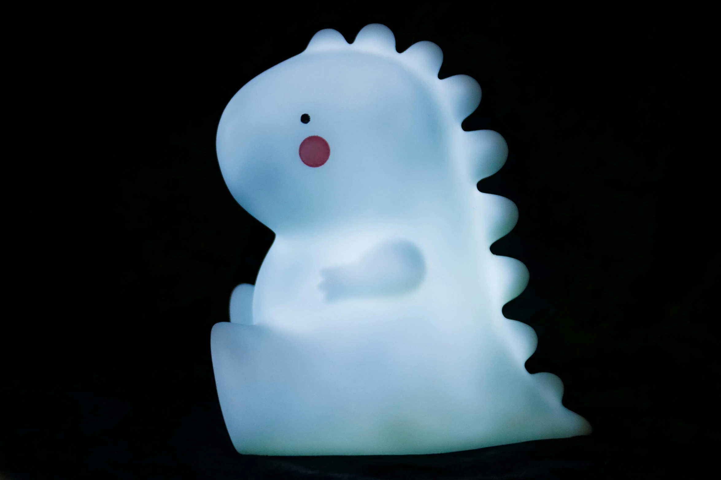 a light that is sitting on top of a table, a cartoon, inspired by Leo Leuppi, mingei, alosaurus, soft white glow, ghost, spiky