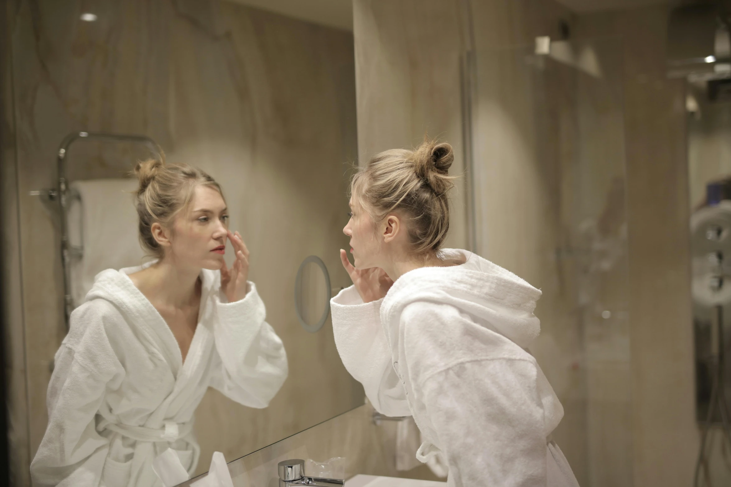 a woman brushing her teeth in front of a mirror, pexels, happening, wearing a grey robe, spa, night time, teenage girl