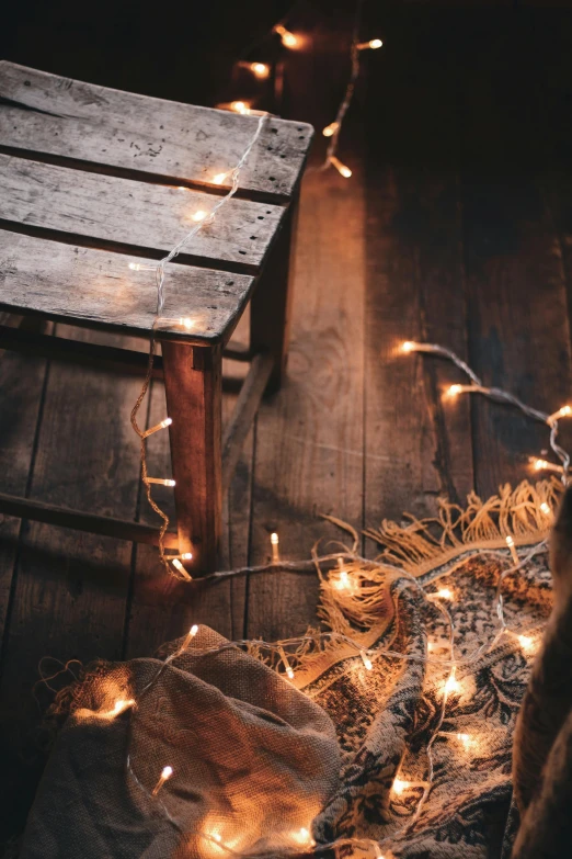 a wooden chair sitting on top of a wooden floor, a portrait, inspired by Elsa Bleda, trending on pexels, light and space, string lights, glowing pumpkins under a tree, santa inside a rustic barn, woven with electricity