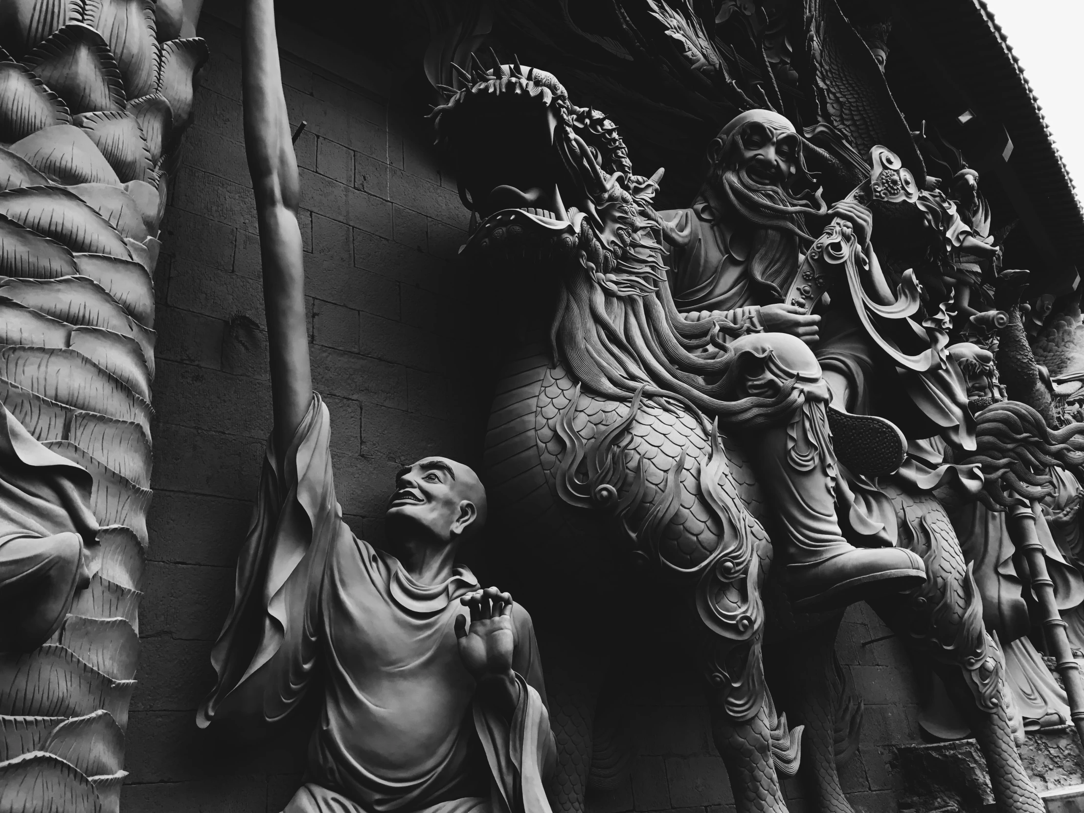 a black and white photo of statues on the side of a building, a statue, inspired by Yue Minjun, pexels contest winner, gothic art, jesus riding a dragon, vietnamese temple scene, cgsociety 9, detailed clay model