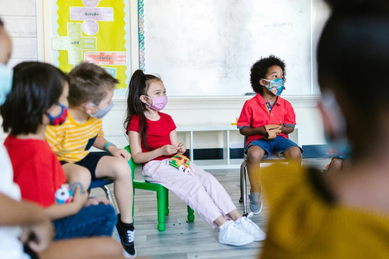 a group of children sitting in front of a whiteboard, by Nicolette Macnamara, pexels, people are wearing masks, sunny day time, high-res, 8 k -