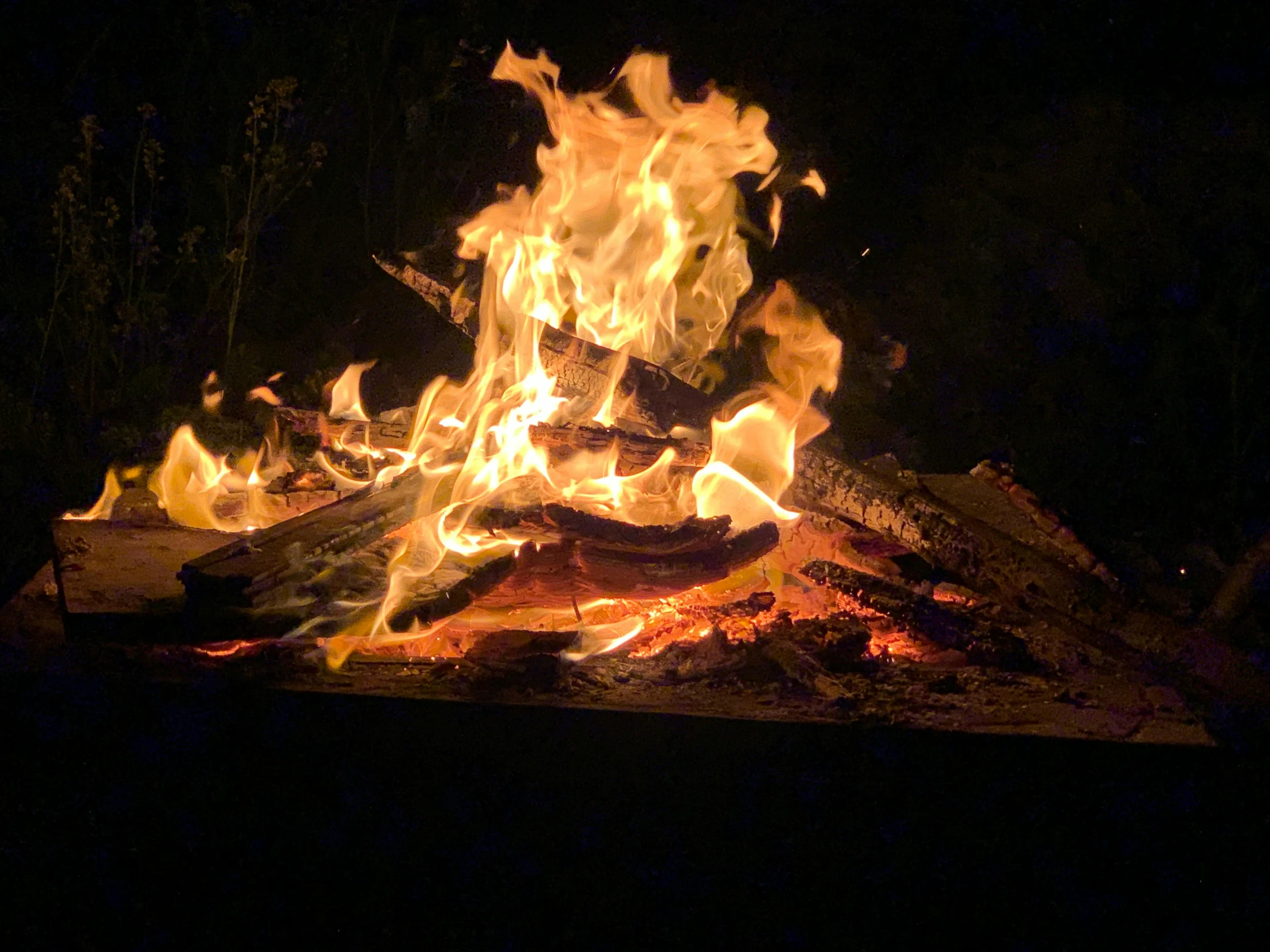 a bunch of hot dogs sitting on top of a fire, an album cover, pexels, night outdoors, profile image, a wooden, fire poi