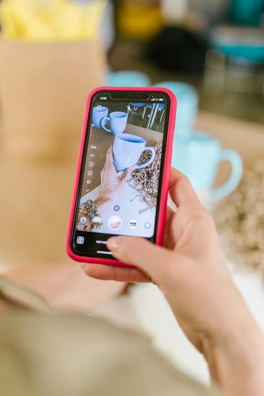 a person taking a picture of a cup of coffee, by Julia Pishtar, happening, pink and blue colour, mobile app, home video footage, high quality photo