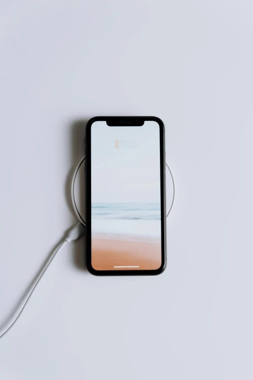 an iphone sitting on top of a white table, by Carey Morris, trending on pexels, minimalism, electricity, plasma, rounded, ox