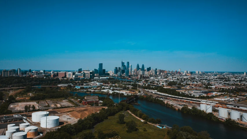 a large body of water with a city in the background, by Jacob Burck, pexels contest winner, always sunny in philadelphia, drone footage, blue river in the middle, 15081959 21121991 01012000 4k