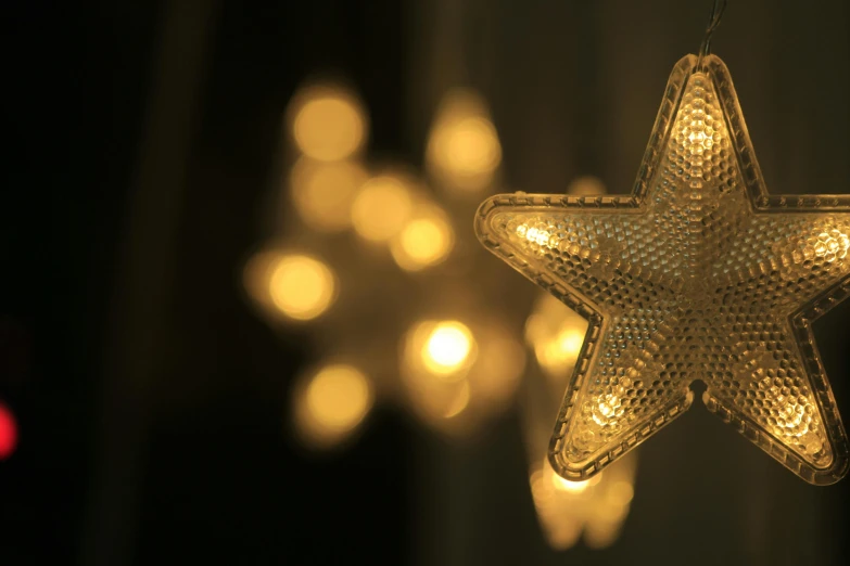 a star hanging from a string of lights, pexels, arabesque, close up shot from the side, highly detailed shot, front lit, rendered in keyshot