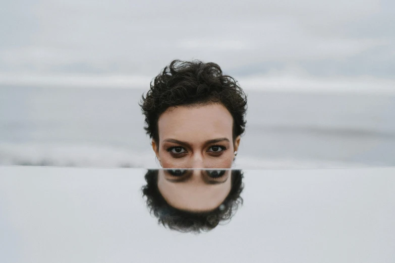 a woman's face reflected in a mirror, an album cover, pexels contest winner, body of water, heath clifford, androgynous male, unsplash transparent