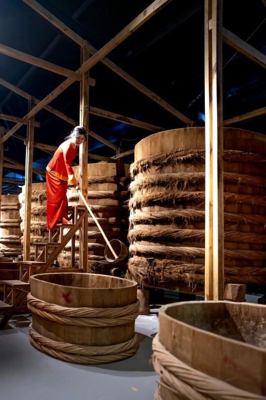 a man that is standing in front of a bunch of barrels, inspired by Li Di, incense, making of, inside building, rice