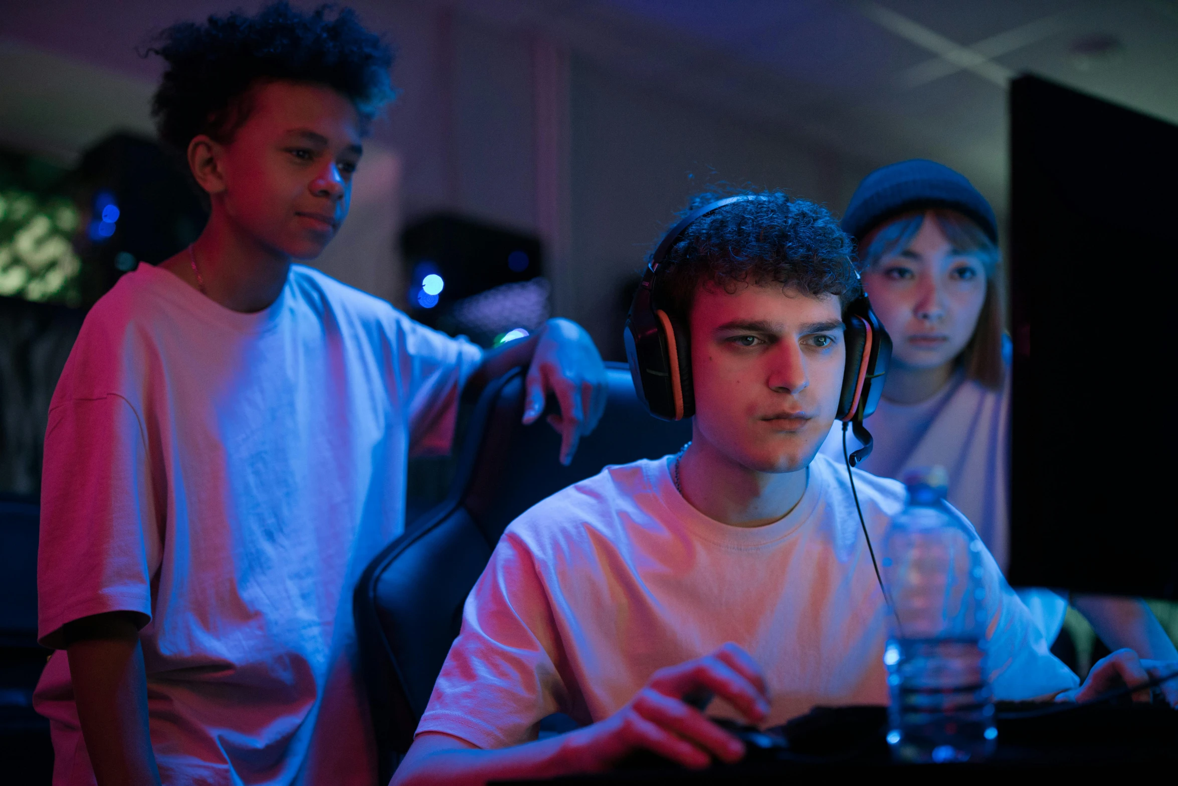 a group of young men sitting in front of a computer, wearing a gaming headset, avatar image, shot with sony alpha 1 camera, penguinz0