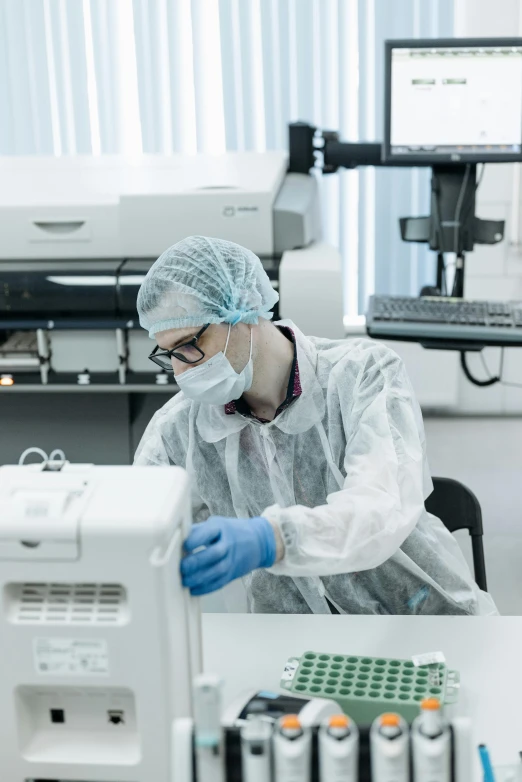 a man in a lab coat working on a machine, a picture, sterile colours, a wide shot, thumbnail, profile image