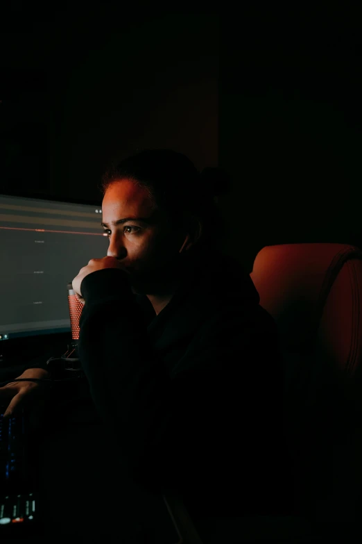 a man sitting in a chair in front of a computer, a picture, inspired by Elsa Bleda, pexels, calm night. over shoulder shot, bella poarch, dark screen, thoughtful )