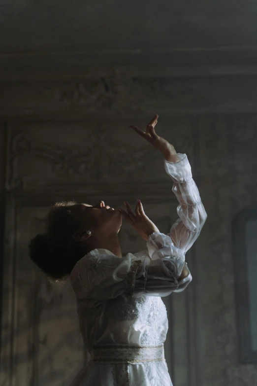 a woman in a white dress standing in a room, by Elizabeth Polunin, pexels contest winner, rococo, performing a music video, solemn gesture, show from below, andrey tarkovsky
