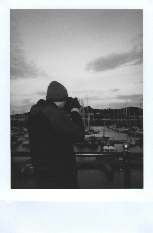 a black and white photo of a person taking a picture, a black and white photo, by Bascove, hugging, harbor, polaroid film, rhys lee