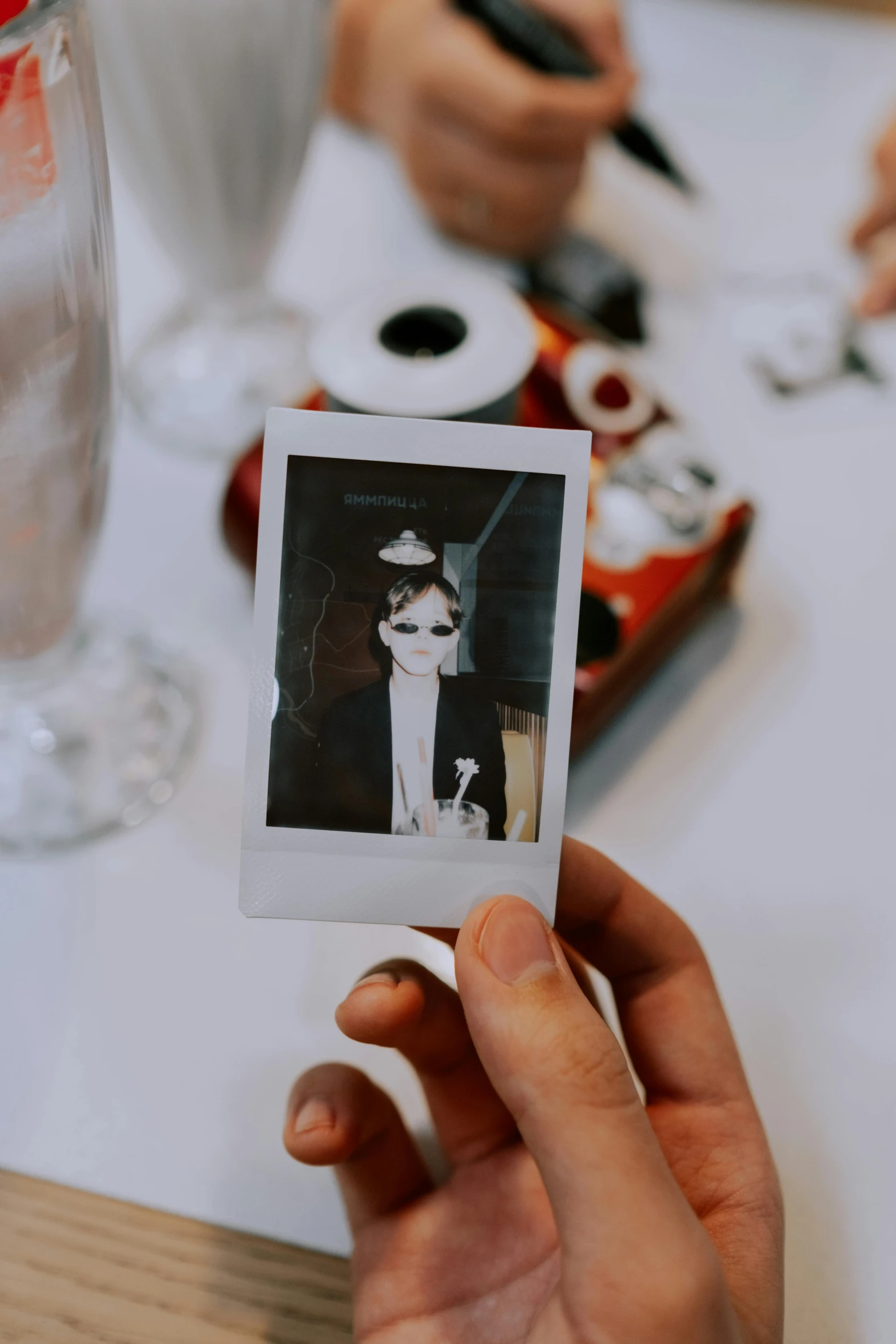 a person holding a polaroid picture of a cat, a polaroid photo, unsplash, serial art, scene from a dinner party, portrait of sadako of the ring, old hollywood themed, professional photo-n 3