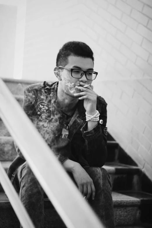 a man sitting on some stairs smoking a cigarette, an album cover, inspired by Huang Gongwang, unsplash, realism, wears glasses, aykut aydogdu, monochrome!!!!!, androgynous male