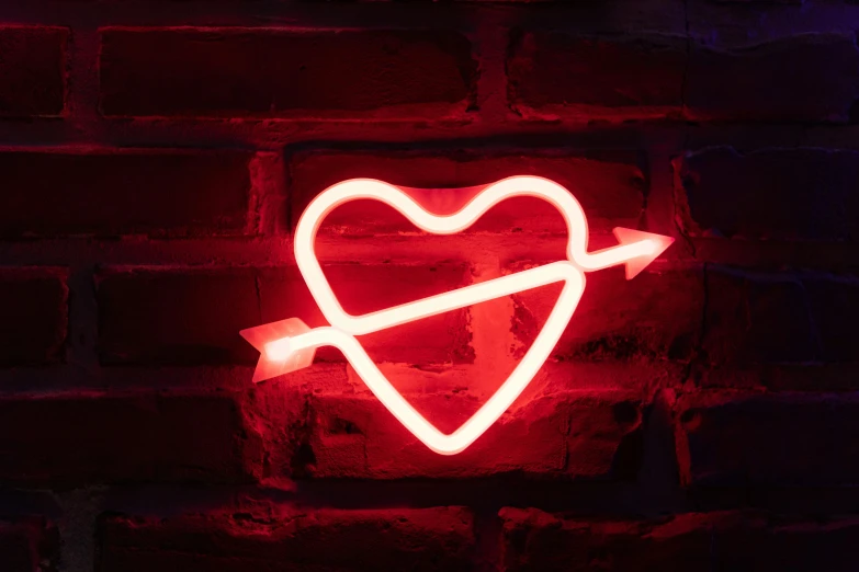 a neon heart with an arrow on a brick wall, by Tracey Emin, pexels, neon standup bar, scarlet, gothic harts, infinite