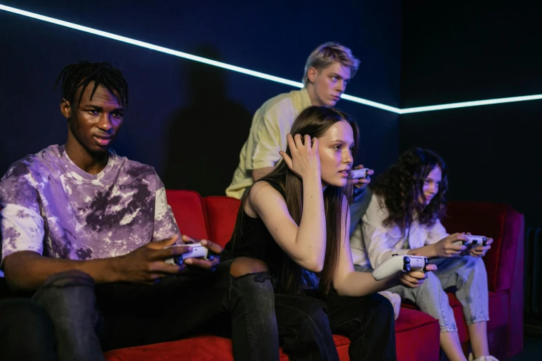 a group of people sitting on top of a red couch, pexels, realism, led gaming, teenage girl, looking threatening, a busy arcade