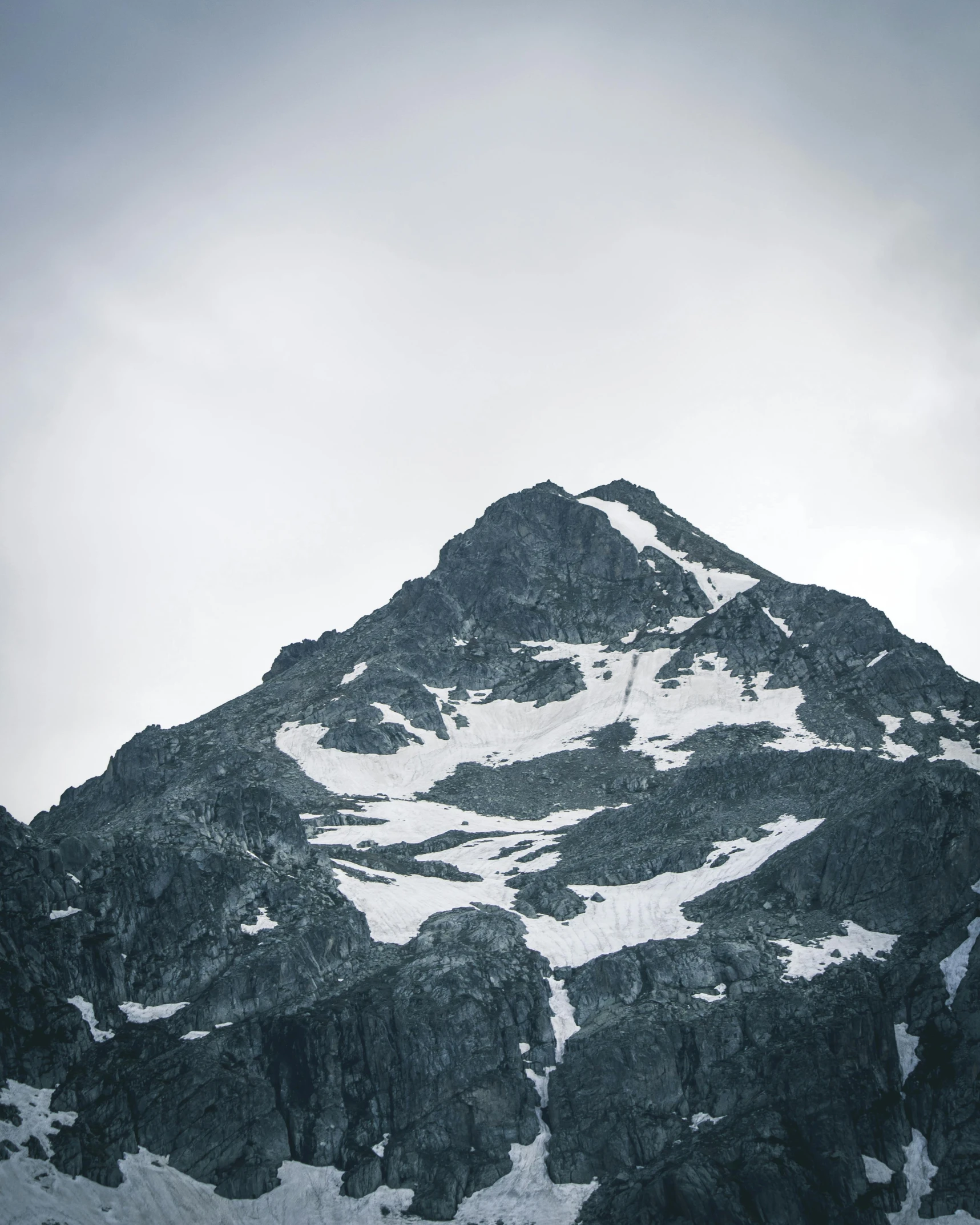 a mountain covered in snow under a cloudy sky, trending on unsplash, hurufiyya, vintage photo, rugged face, no cropping, stacked image