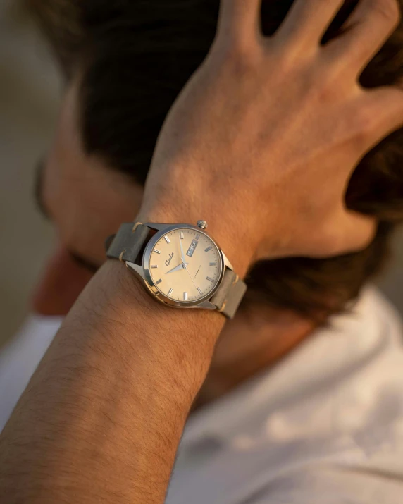 a man with a watch on his wrist, light grey mist, wearing spiky, seaside, a high angle shot