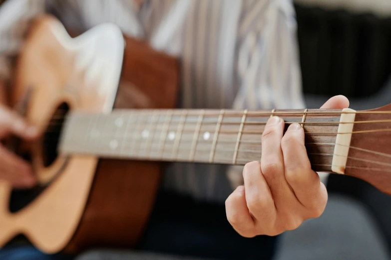 a close up of a person playing a guitar, inspired by James Bard, trending on pexels, hurufiyya, lachlan bailey, finely detailed feature, no cropping, thumbnail