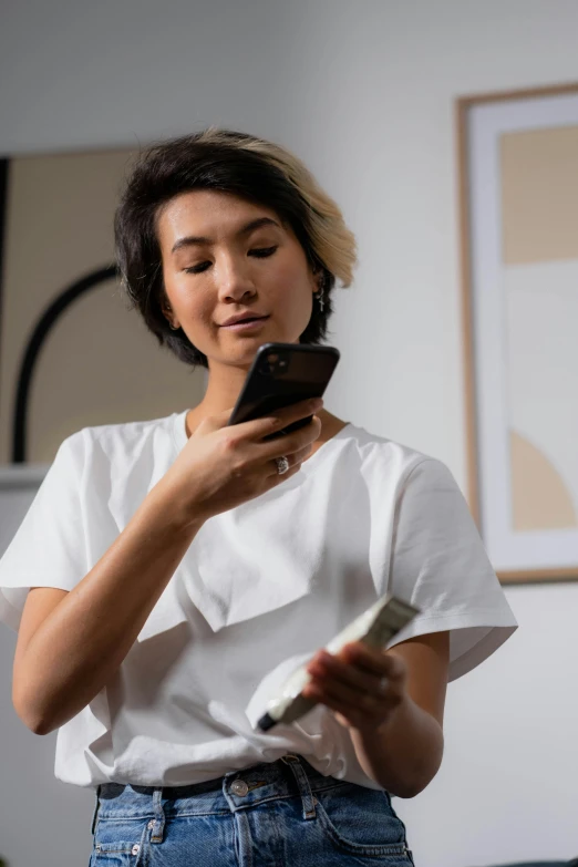 a woman standing in a living room looking at her cell phone, trending on pexels, happening, asian human, samsung smartthings, non binary model, “ painting