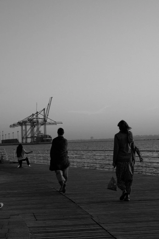 a black and white photo of people walking on a pier, a black and white photo, in sci - fi mumbai, ships, :: morning, friendship