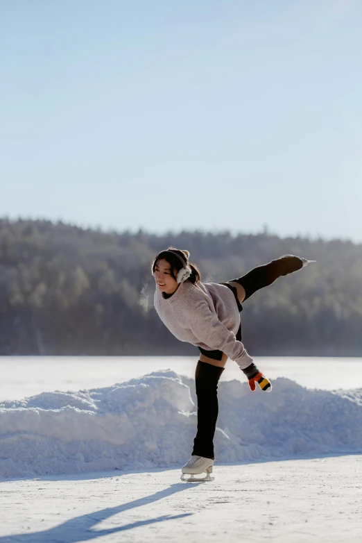 a woman riding a skateboard across a snow covered field, by Jaakko Mattila, arabesque, yoga pose, on a lake