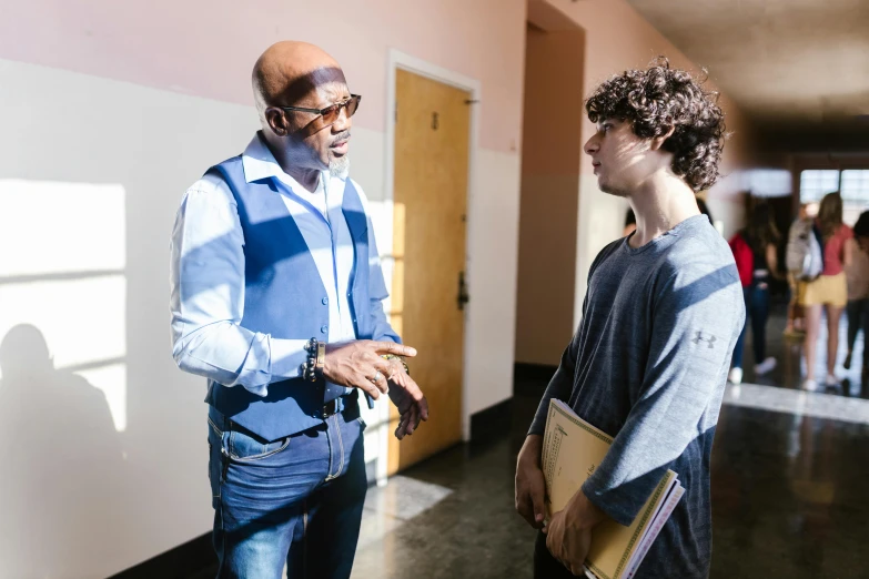 a man standing next to another man in a hallway, teaching, kevin garnett, on set, profile image