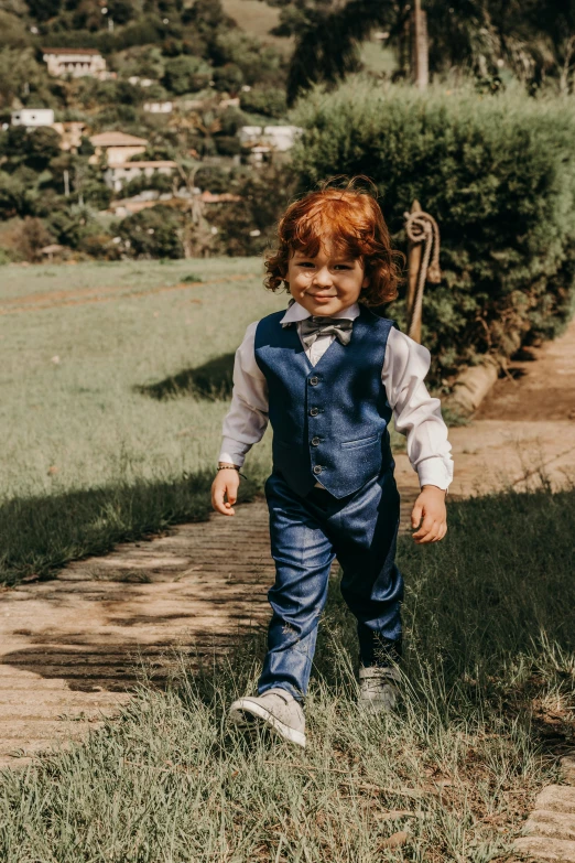 a little boy that is standing in the grass, an album cover, pexels, happening, suit and waistcoat, walking towards camera, toys, wedding