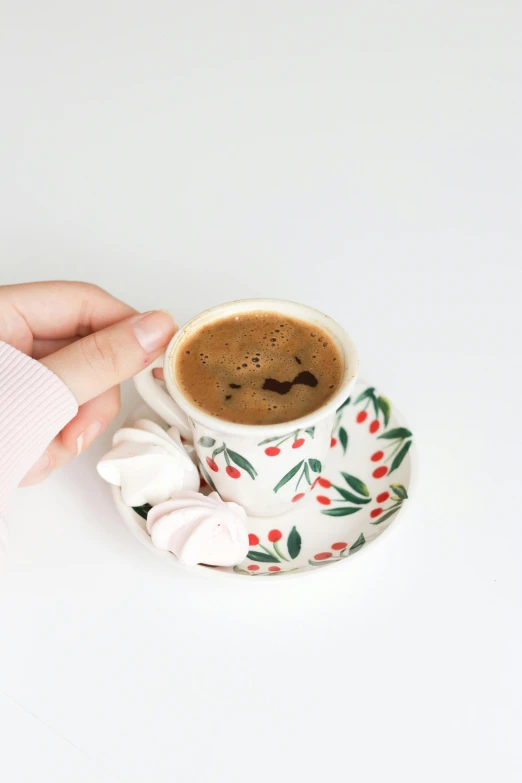 a close up of a person holding a cup of coffee, floral patterned skin, with a white background, mina petrovic, detailed product image