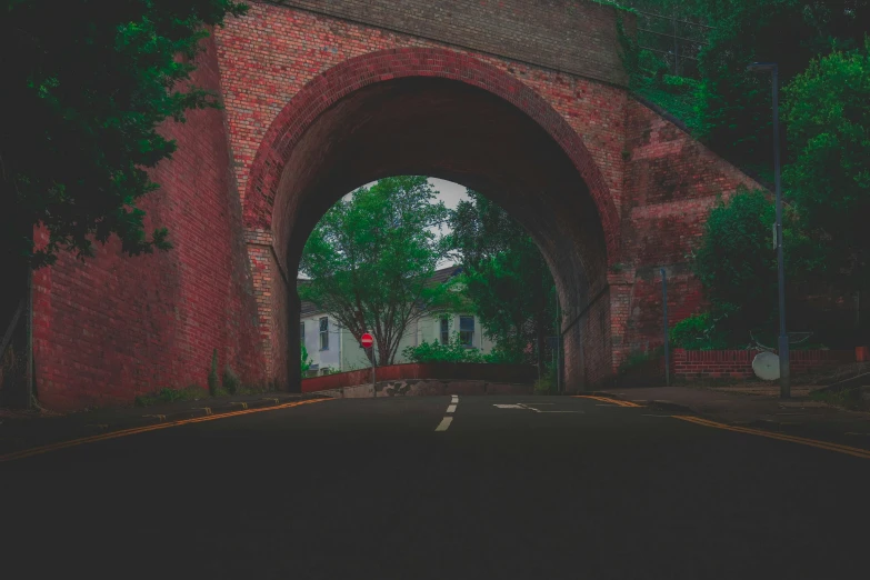 a red brick arch on the side of a road, a picture, inspired by Elsa Bleda, unsplash contest winner, muted colours 8 k, very terrifying, driving through a 1 9 5 0 s town, underground