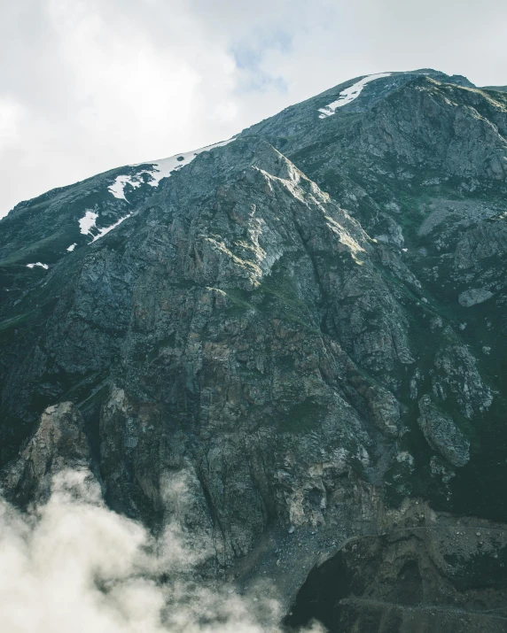 a man riding a snowboard on top of a snow covered mountain, an album cover, pexels contest winner, hurufiyya, extremely detailed rocky crag, “ aerial view of a mountain, granite, unsplash 4k