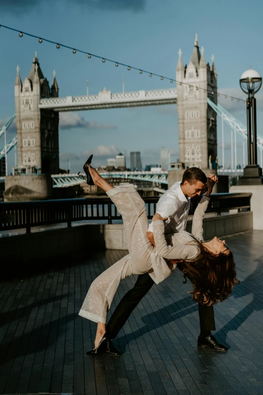 a man and woman doing a handstand in front of tower bridge, arabesque, modern dance aesthetic, on ship, hug, #trending