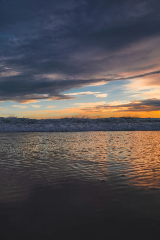 a man riding a surfboard on top of a sandy beach, during a sunset, today\'s featured photograph 4k, wall of water either side, abel tasman