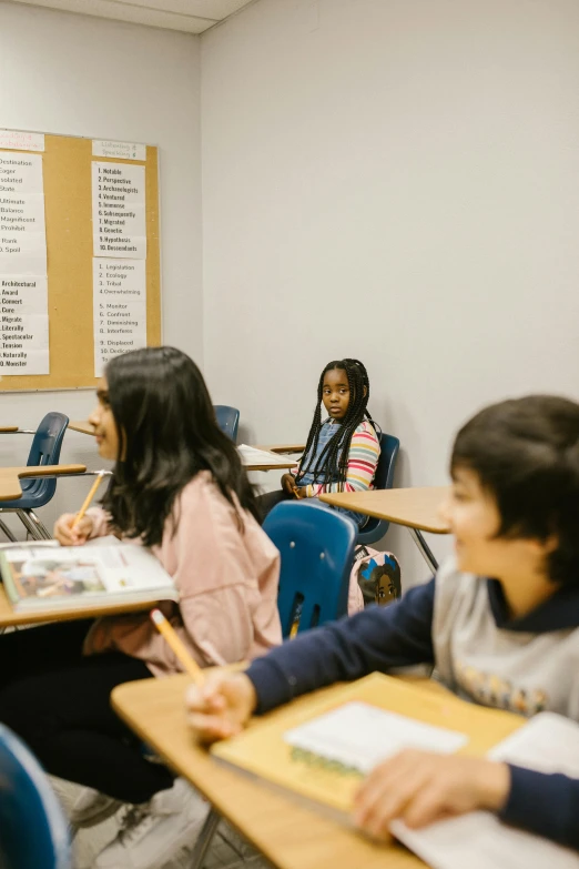 a group of children sitting at desks in a classroom, a picture, by Matt Cavotta, pexels contest winner, american barbizon school, profile pic, promo image, contemplating, thumbnail