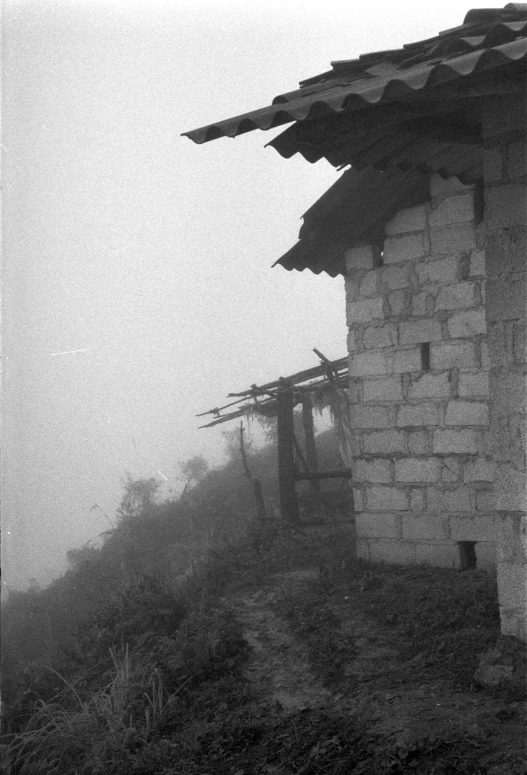 a black and white photo of a small building, a black and white photo, by Albert Welti, mingei, shan shui, ((mist)), old film, mountainside