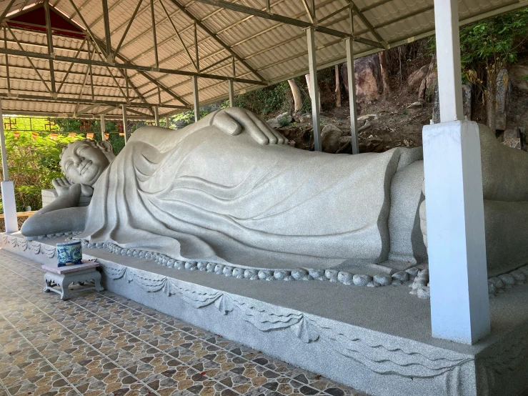 a statue of a person laying on a bench, large temples, avatar image