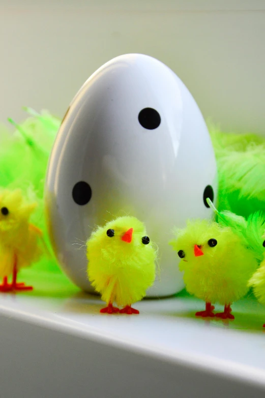 a group of chicks standing next to an egg, happening, feather boa, green and yellow, with fluo colored details, on